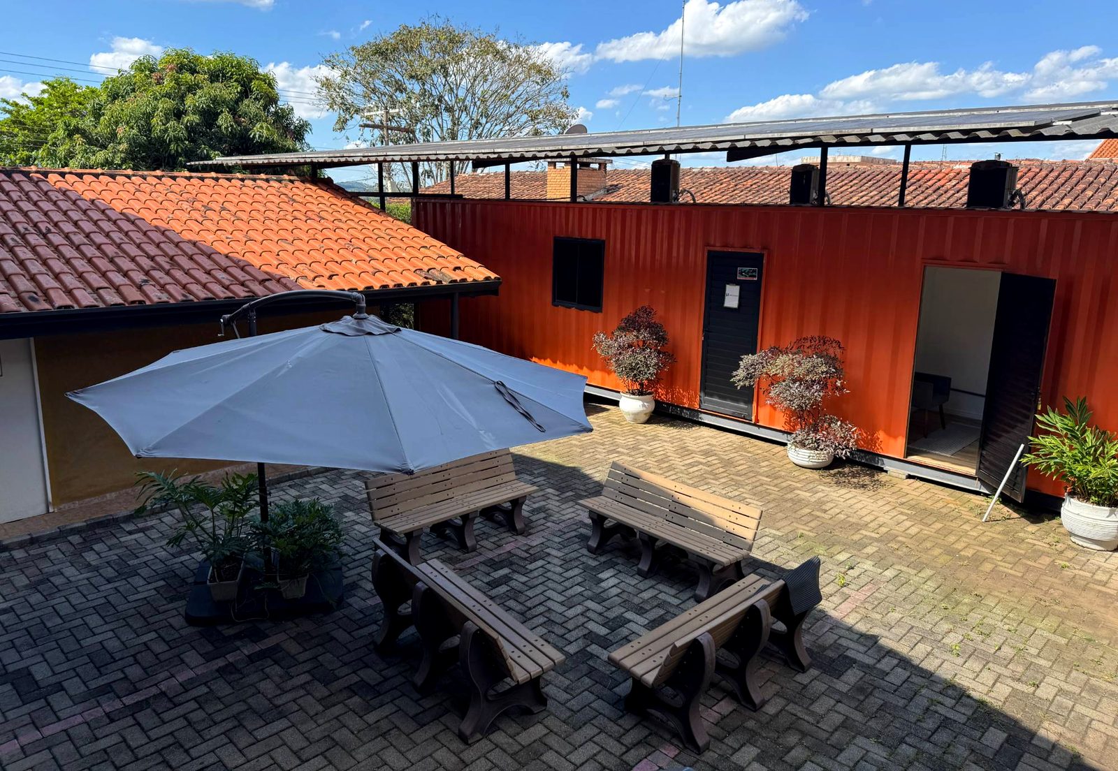 Pátio do escritório da Agência Mesa8, com o contentor laranja da equipa